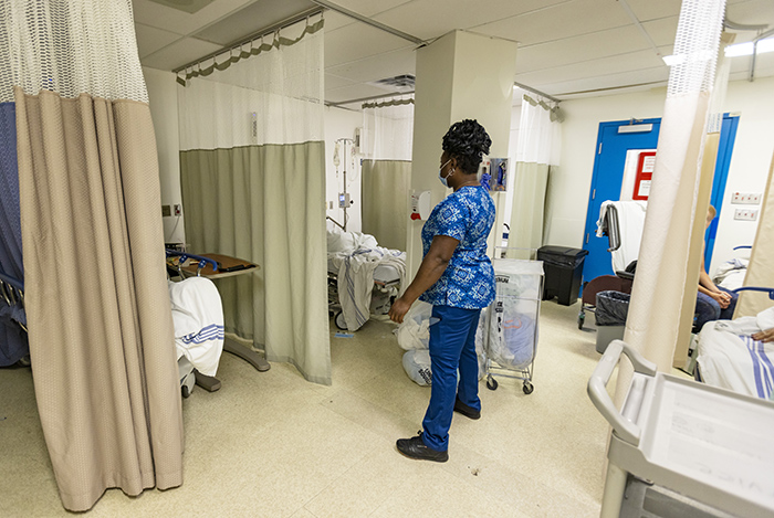 Nurse stands in disheveled hospital ward