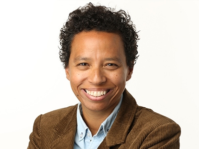 Lydia Polgreen, a smiling woman with close-cropped hair wearing a brown corduroy jacket and light blue collared shirt